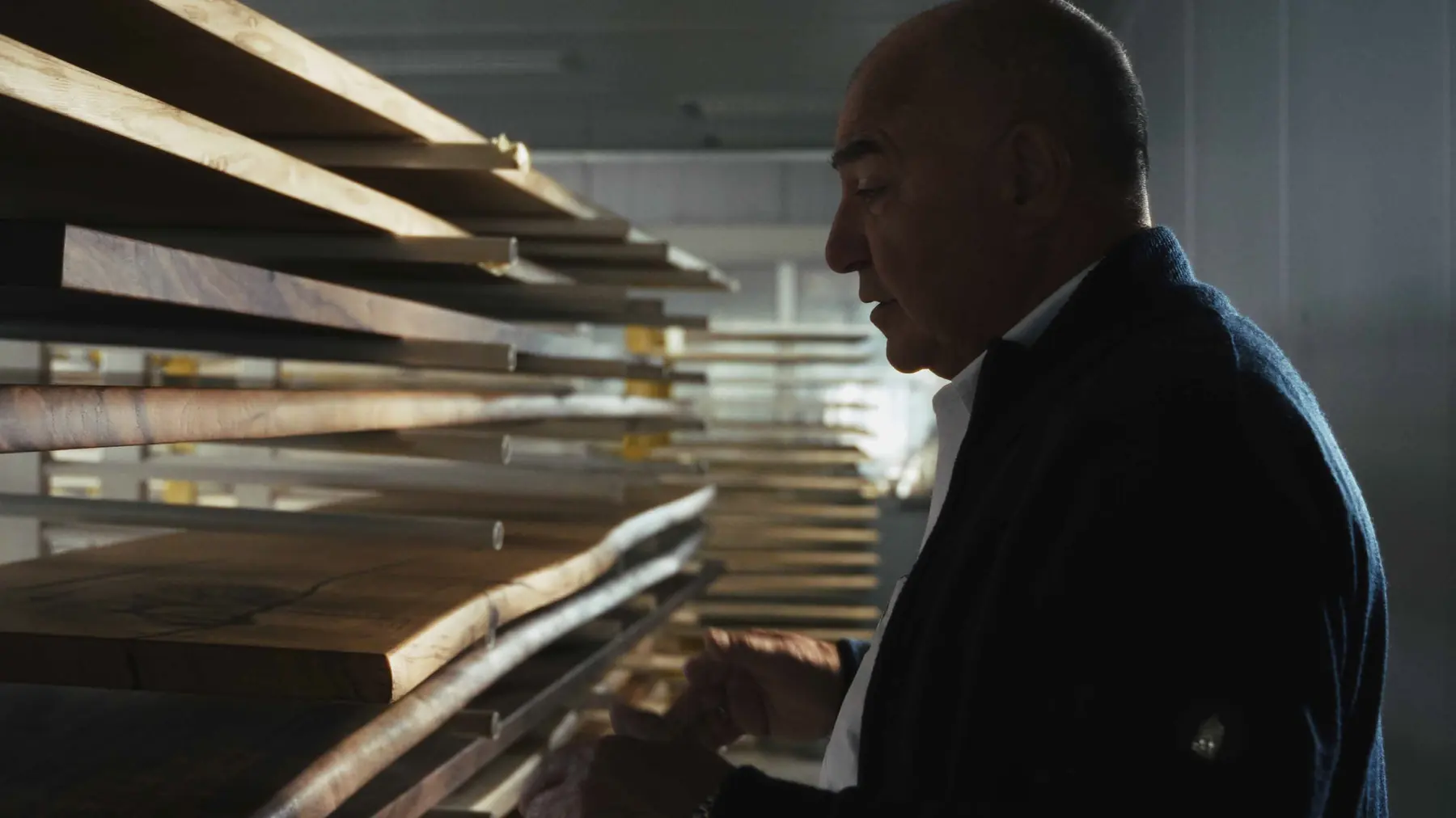 A man checking a rack of drying slabs in the workshop